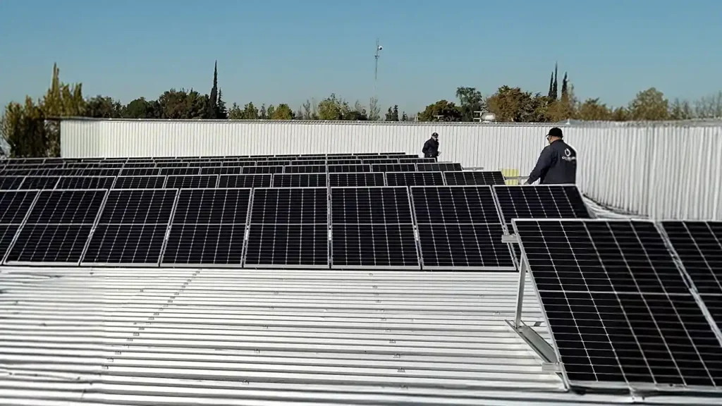 Técnicos instalando paneles solares sobre techo metálico en industria Itecra