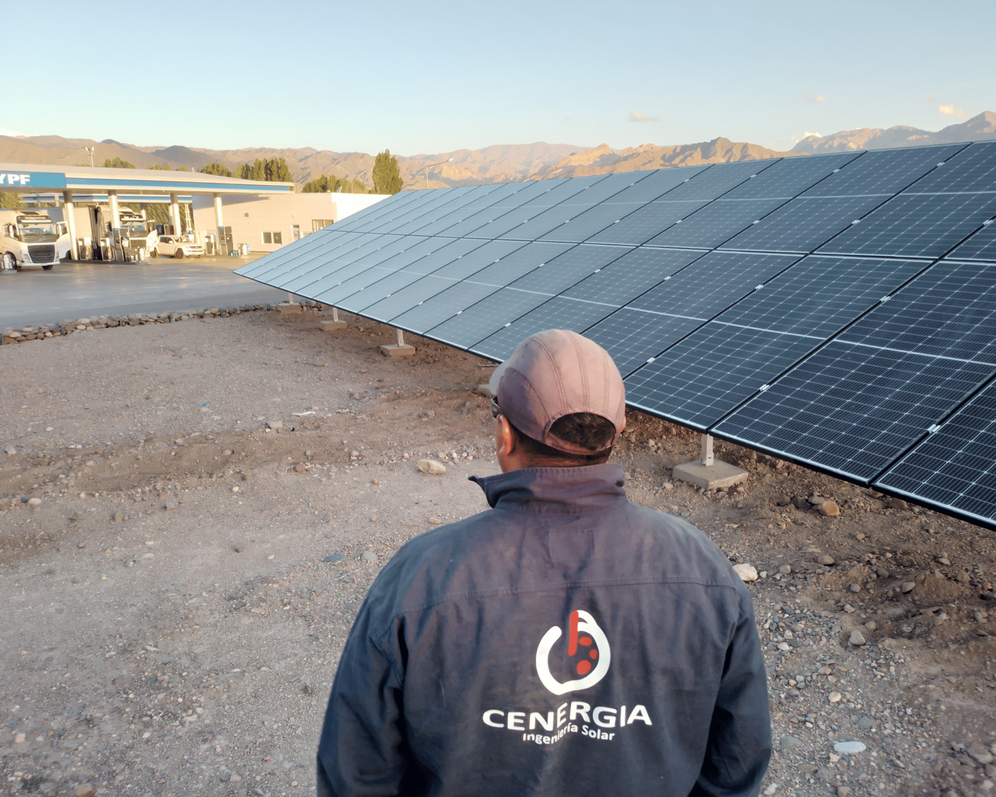 Ingeniero de Cenergia de espaldas frente a instalación de paneles solares en YPF Upsallata